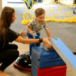 Child playing with colorful toys during a pediatric physical therapy evaluation at Move U clinic in Sioux Falls