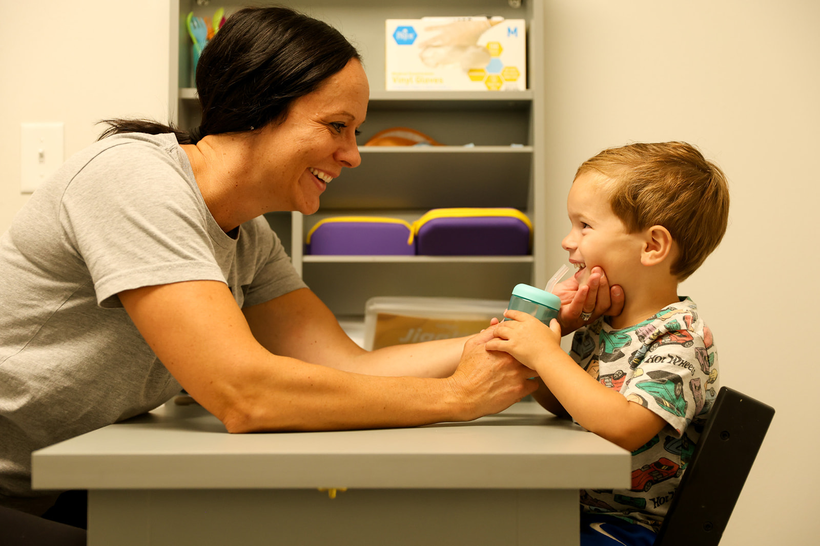 MOVEU Content // 2025 Speech therapist at Move U Sioux Falls working with a young child on feeding and oral motor skills in a calm play-based setting